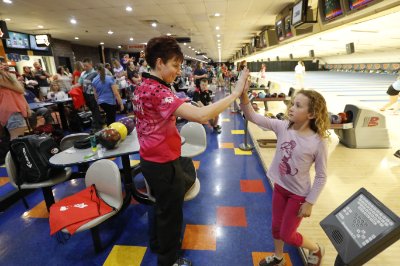 Shannon Pluhowsky giving a young fan high-five at a PWBA Tour event.